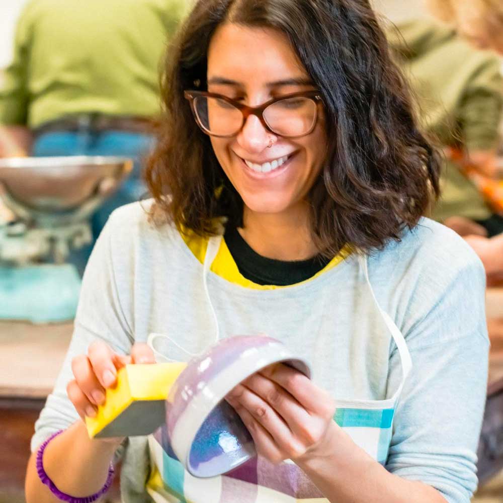 Learner working on a ceramic bowl in a pottery class.