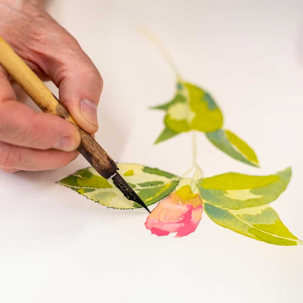 Hand painting a botanical illustration of a flower.