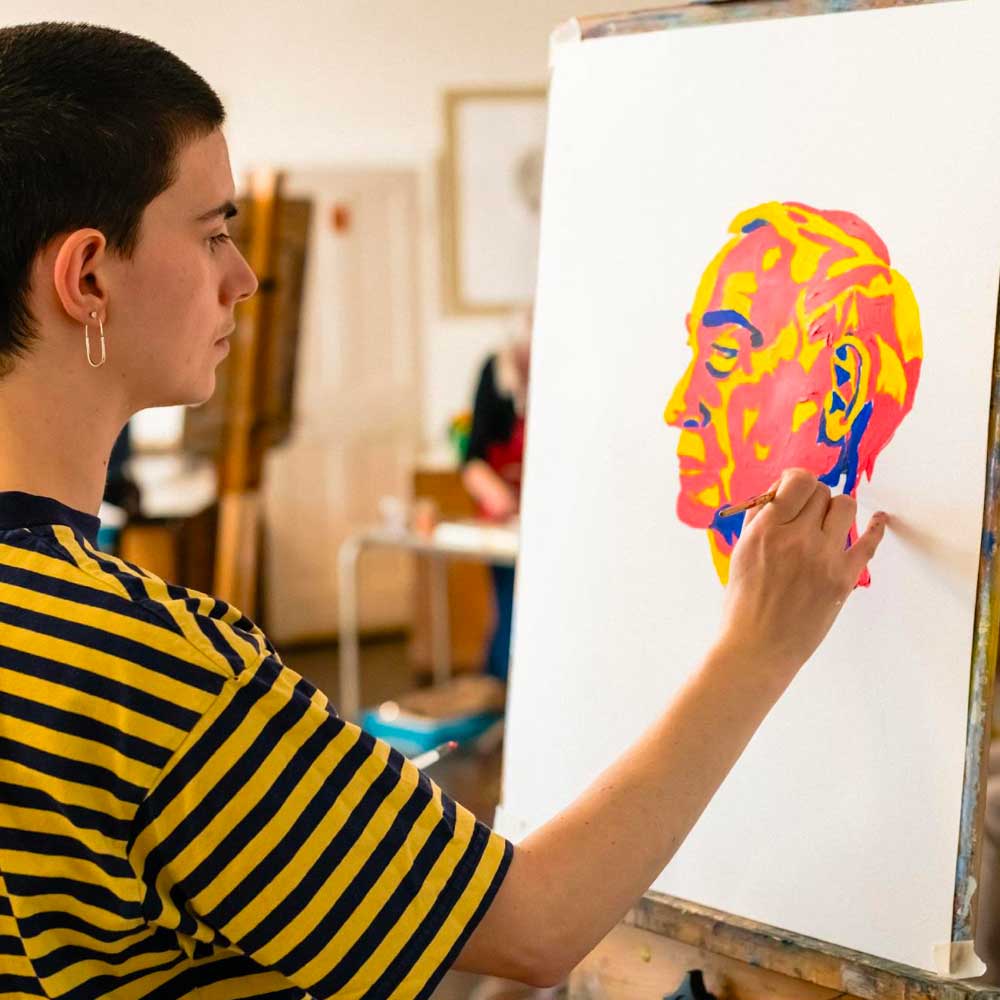 Learner sketching a portrait on a drawing board.