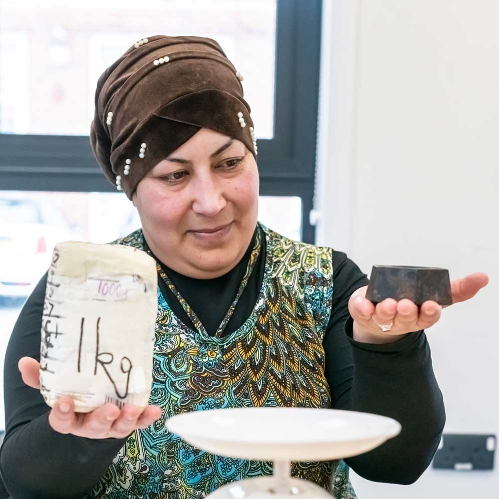 Learner weighing objects by hand.