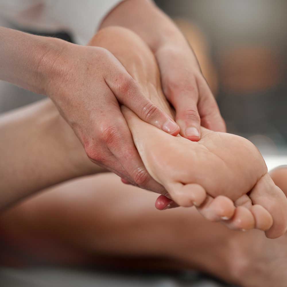 Learners giving and receiving a reflexology foot treatment.