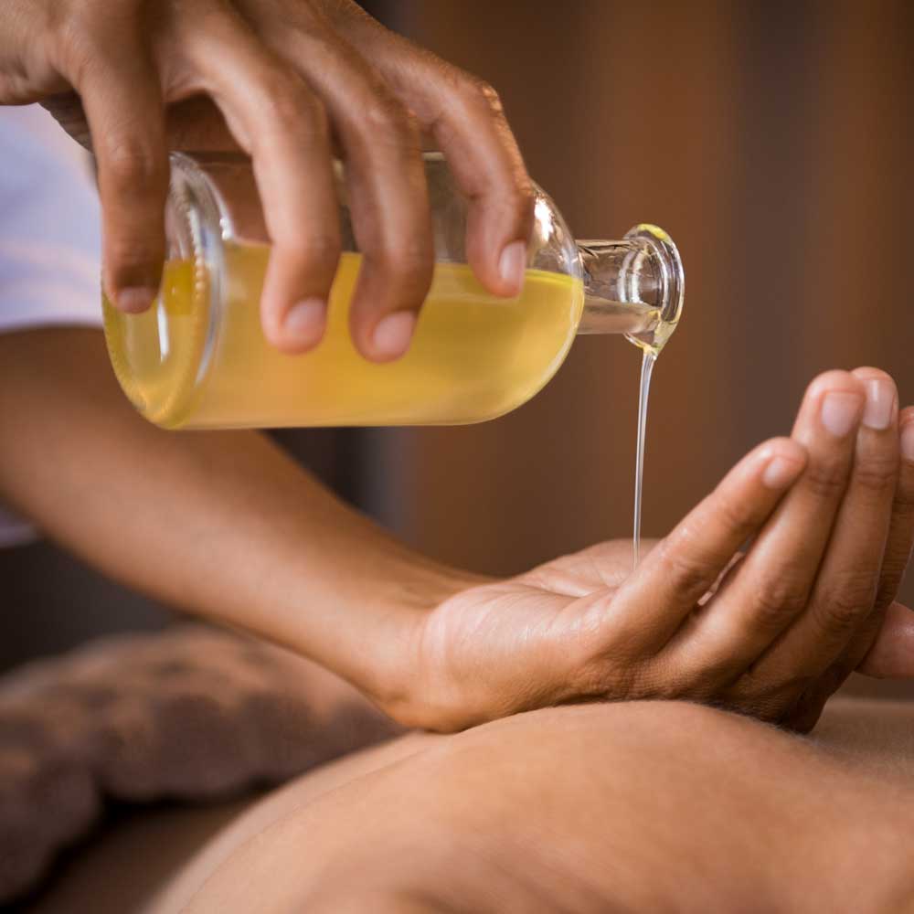 Massage oil being poured onto a hand.