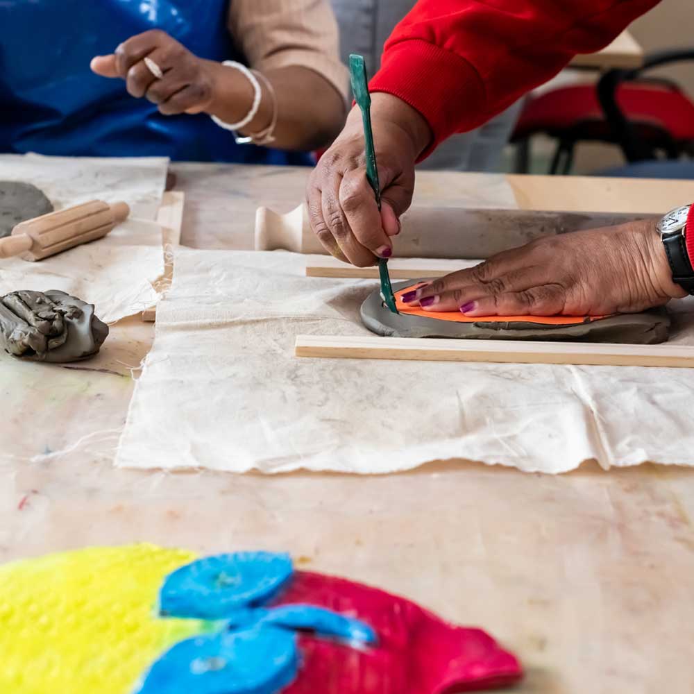 Adult shaping clay during a creative Mindlift workshop.