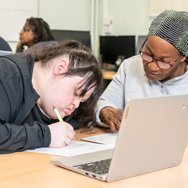 Learner receiving one-to-one support while completing a work.