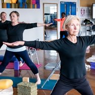Adults taking part in a group yoga session.