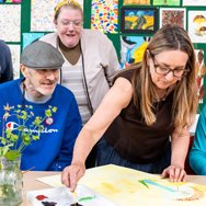 Adults taking part in a supported learning art activity.