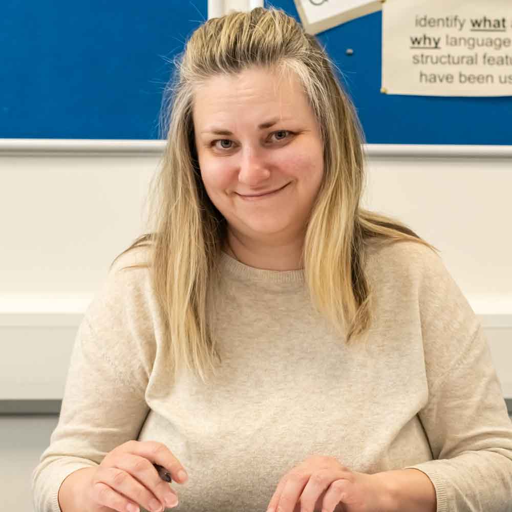 Learner smiling at desk.