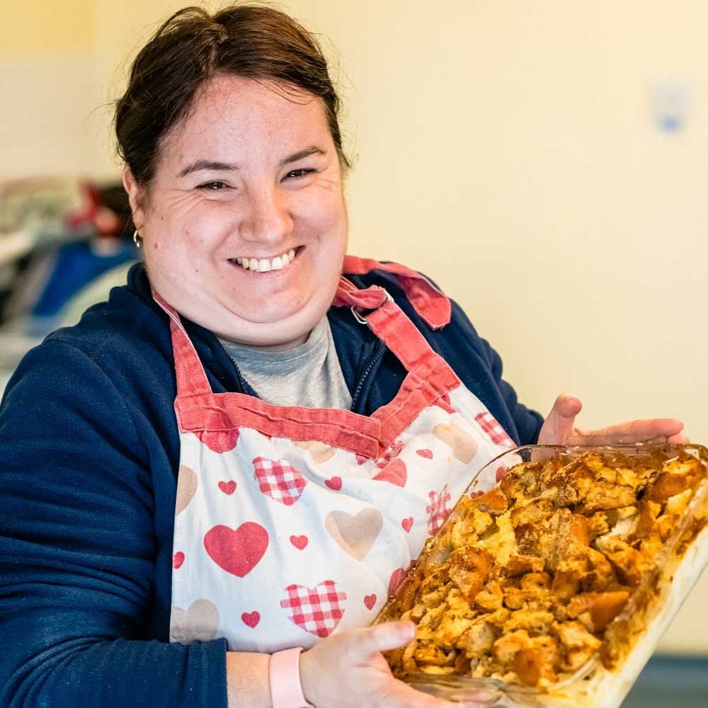 Learner presenting a tray of homemade food during a life skills session.