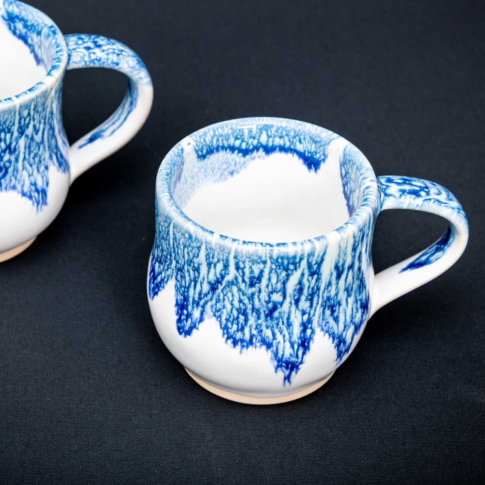 Decorated ceramic mugs on a table.