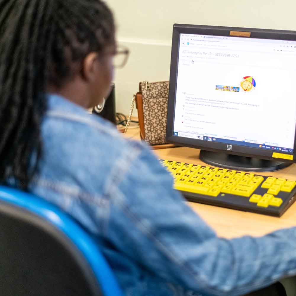 Learner using an accessible computer with a high-contrast keyboard.