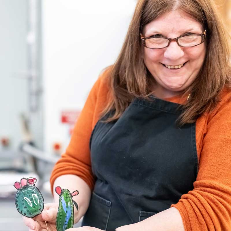 Learner smiling while making glass art pieces